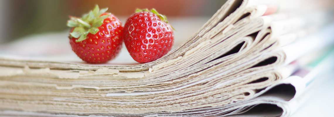 Symbolbild Adobestock 219511922 Erdbeeren auf Zeitungsstapel