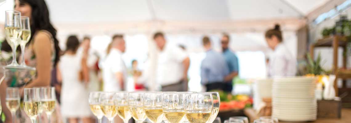 Sympolbild Businessparty Adobe Stock 224673913 Party Sektgläser vorn Gäste unscharf im Hintergrund